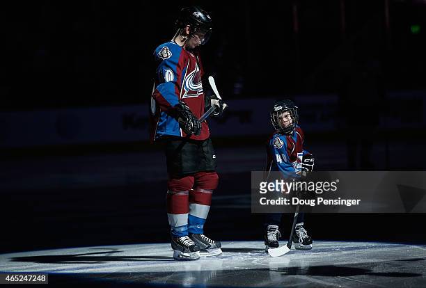 Alex Tanguay of the Colorado Avalanche takes the ice with his son Samuel prior to facing the Pittsburgh Penguins in his 1000th career NHL game at...
