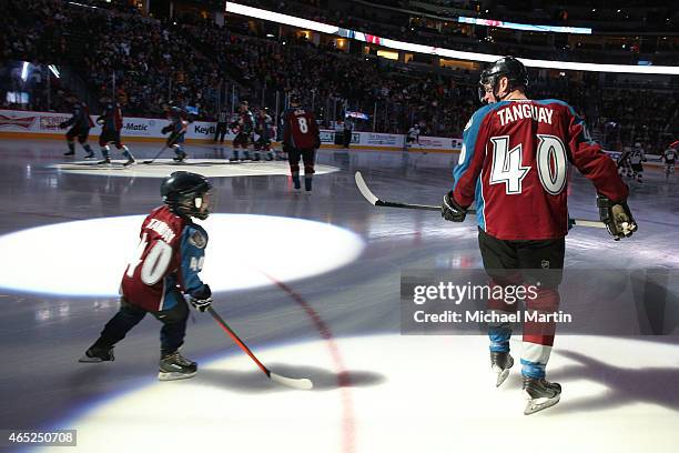 Alex Tanguay of the Colorado Avalanche skates with his son Samuel prior to his 1000th career NHL game against the Pittsburgh Penguins at the Pepsi...