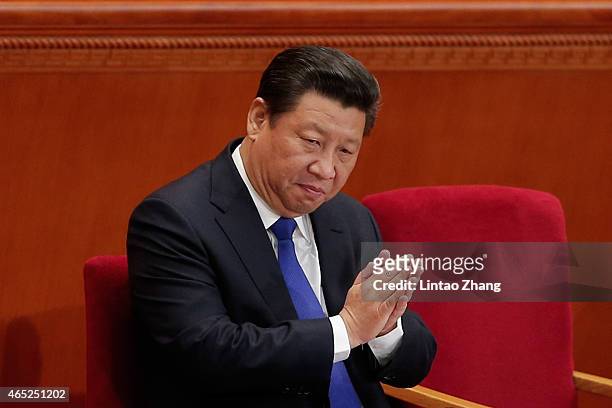 Chinese President Xi Jinping applauds during the opening of the 3rd Session of the 12th National People's Congress at the Great Hall of the People on...