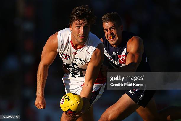 Viv Michie of the Demons handballs against Stephen Hill of the Dockers during the NAB Challenge match between the Fremantle Dockers and the Melbourne...
