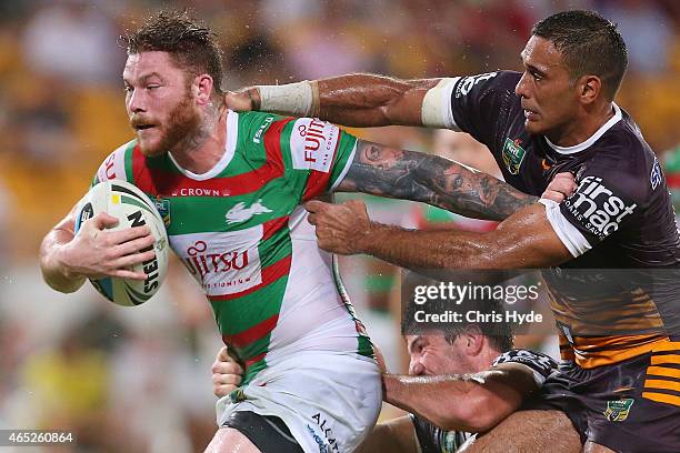 Chris McQueen of the Rabbitohs is tackled by Justin Hodges of the Broncos during the round one NRL match between the Brisbane Broncos and the South...