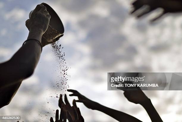 Woman winnows grain to separate sorghum seeds from soil after collecting seeds off the ground following an air-drop at a village in Nyal, an...