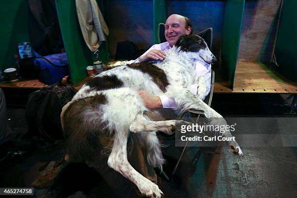 An owner cuddles his Russian Borzoi on the first day of Crufts dog show at the National Exhibition Centre on March 5, 2015 in Birmingham, England....