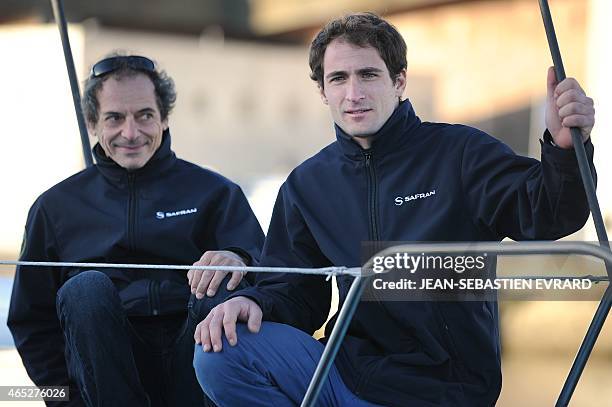 French skippers Morgan Lagraviere and Marc Guillemot pose as the new Class Imoca Monohull "Safran" is launched on March 5, 2015 in Lorient, western...