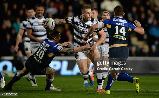 Joe Westerman of Hull FC is tackled by Jamie Peacock and Stevie Ward of Leeds Rhinos during the First Utility Super League match between Hull FC and...