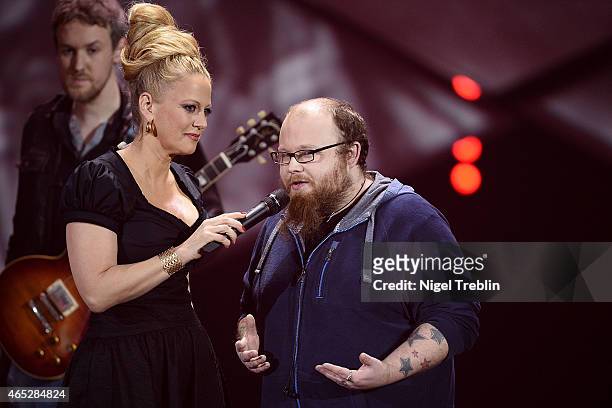 Singer Andreas Kuemmert reacts next to host Barbara Schoeneberger during the finals of the TV show 'Our Star For Austria' on March 5, 2015 in...