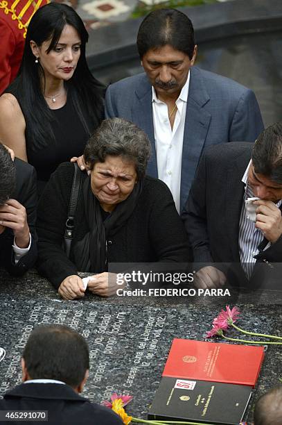 The mother of late President Hugo Chavez, Elena Frias reacts as she leans over his tomb, during a ceremony for the second anniversary of his demise...