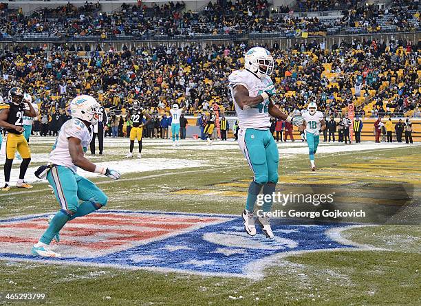 Tight end Charles Clay of the Miami Dolphins celebrates after scoring a touchdown on a 12-yard pass play as teammate Daniel Thomas looks on during a...