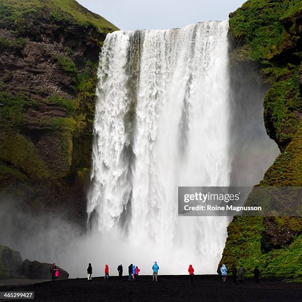 tourists at the waterfall - skogafoss waterfall stock pictures, royalty-free photos & images