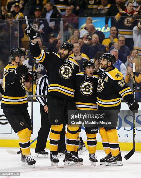 Dougie Hamilton, Zdeno Chara, and Patrice Bergeron congratulate Brad Marchand of the Boston Bruins after he scored a goal against the Calgary Flames...