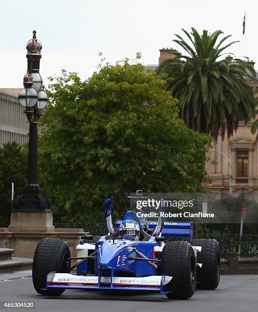 Cameron McConville drives the Swisse two seater Formula One car along Spring Street, ahead of the 2015 Melbourne Formula One Grand Prix at Parliament...