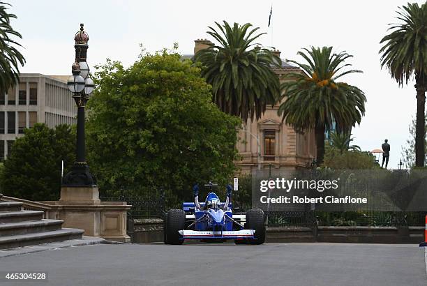 Cameron McConville drives the Swisse two seater Formula One car along Spring Street, ahead of the 2015 Melbourne Formula One Grand Prix at Parliament...