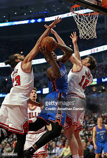 Serge Ibaka of the Oklahoma City Thunder tries to shoot between Joakim Noah and Pau Gasol of the Chicago Bulls at the United Center on March 5, 2015...