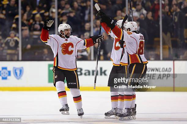 David Schlemko of the Calgary Flames is congratulated by teammates after scoring the game winning goal during a shootout against the Boston Bruins at...