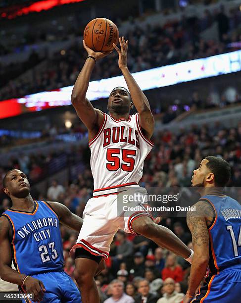Twaun Moore of the Chicago Bulls puts up a shot between Dion Waiters and D.J. Augustin of the Oklahoma City Thunder at the United Center on March 5,...