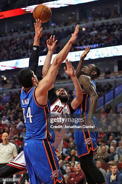 Nikola Mirotic of the Chicago Bulls tries to get off a shot between Enes Kanter and Anthony Morrow of the Oklahoma City Thunder at the United Center...