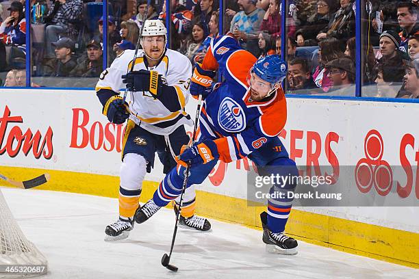 Jesse Joensuu of the Edmonton Oilers skates with the puck against Colin Wilson of the Nashville Predators during an NHL game at Rexall Place on...