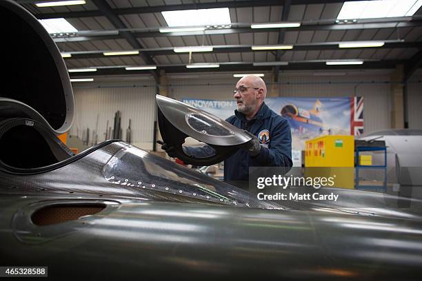 Engineer places the cockpit cover as he works on the carbon-fibre body of the Bloodhound SSC vehicle currently taking shape at its design centre in...