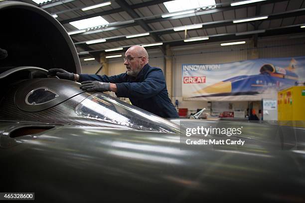 Engineer places the cockpit cover as he works on the carbon-fibre body of the Bloodhound SSC vehicle currently taking shape at its design centre in...