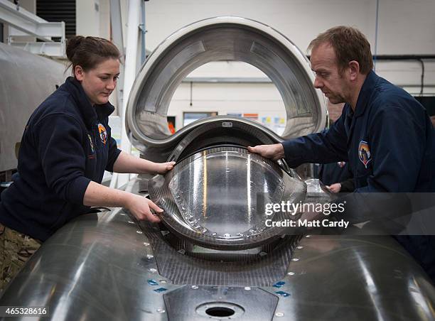 Cpl Kayleigh Williams from the Royal Electrical and Mechanical Engineers and build technician Rupert Byrce-Morris put the cockpit glass cover in...