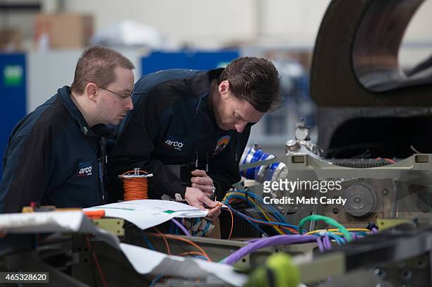 Engineers work on the wiring loom in the rear end of the Bloodhound SSC vehicle currently taking shape at its design centre in Avonmouth on March 5,...
