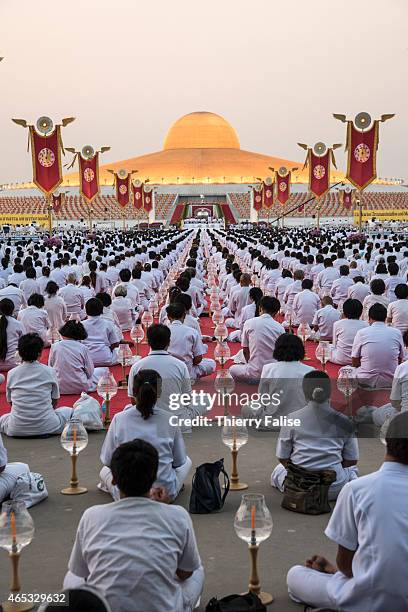 Tens of thousands of Dhammakaya temple's members sit around the so-called Cetiya, a large chedi containing one million Buddha images, during a mass...