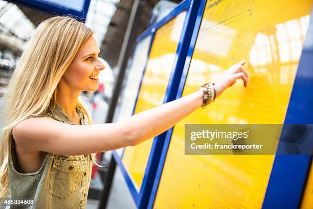 tourist in amsterdam looking the timetable at station - information kiosk stock pictures, royalty-free photos & images