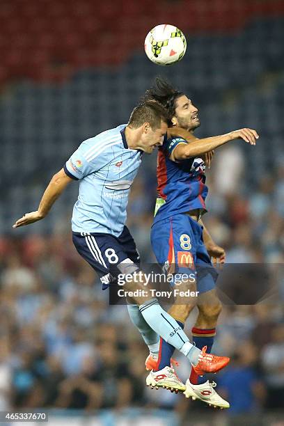 Zenon Caravella of the Jets contests a header with Milos Dimirijevic of Sydney FC during the round 20 A-League match between the Newcastle Jets and...