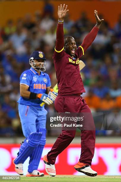 Dwayne Smith of the West Indies celebrates the wicket of Suresh Raina of India during the 2015 ICC Cricket World Cup match between India and the West...