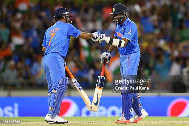 Dhoni of and Ravichandran Ashwin of India celebrate a boundary during the 2015 ICC Cricket World Cup match between India and the West Indies at WACA...