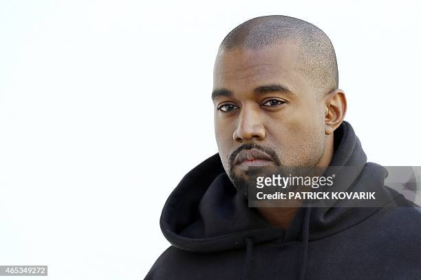 American rapper Kanye West poses before Christian Dior 2015-2016 fall/winter ready-to-wear collection fashion show on March 6, 2015 in Paris. AFP...
