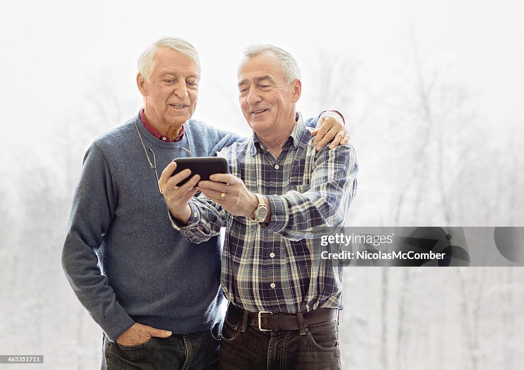 Senior gay couple shooting a selfie with mobile phone