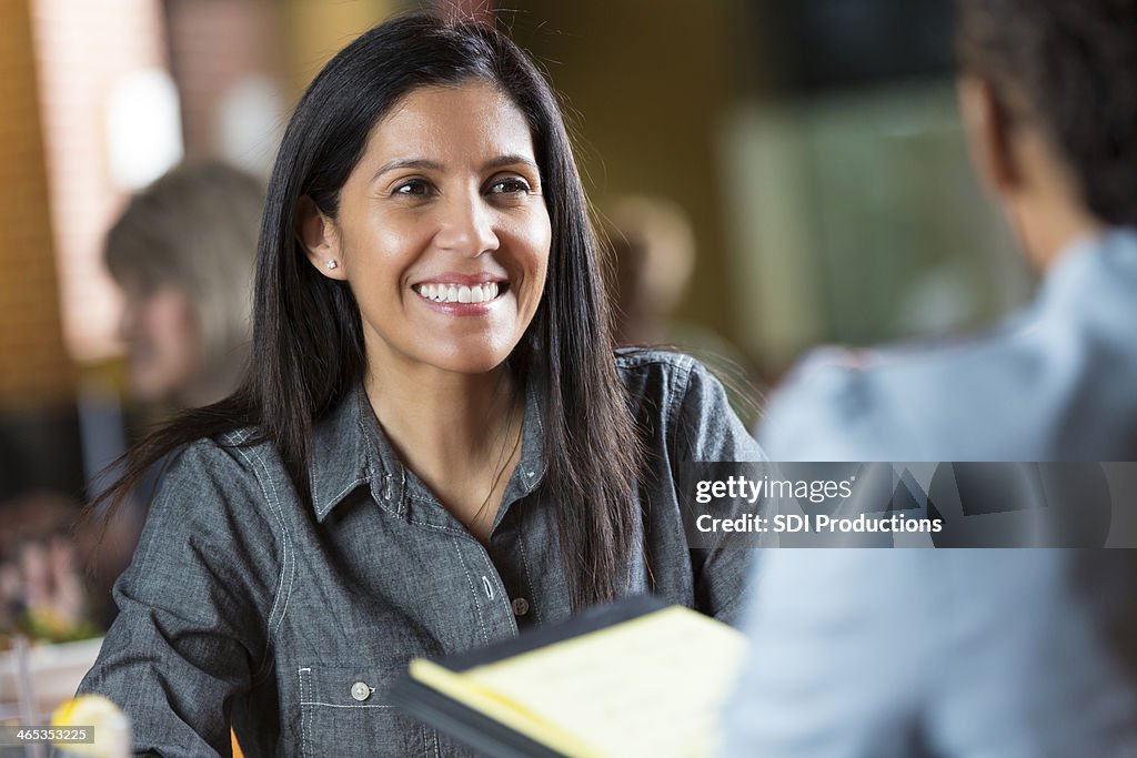 Hispanic woman with resume applying for job during interview meeting