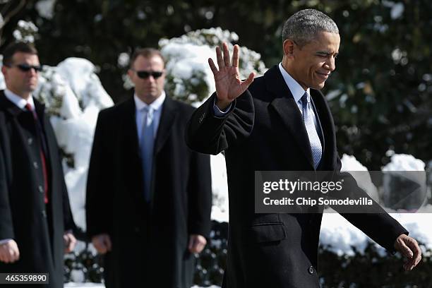 President Barack Obama waves to reporters as he leaves the White House before boarding the Marine One helicopter on the South Lawn March 6, 2015 in...