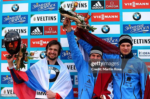 Alexander Tretiakov of Russia , Martins Dukurs of Latvia and Tomass Dukurs of Latvia celebrate after the fourth run of the men's skeleton competition...