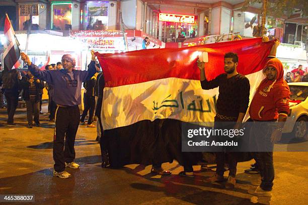 Iraqi soccer fans celebrate in the streets of Baghdad after their national team defeated Saudi Arabia in the AFC U-22 Asian Cup final soccer match on...