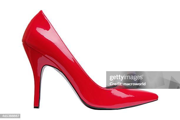 a bright red high heel woman's shoe by itself  - red shoe stockfoto's en -beelden