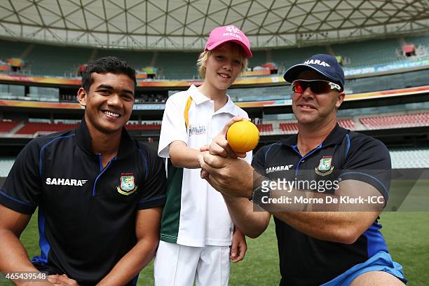 Taskin Ahmed and bowling coach Heath Streak of the Bangladesh Cricket team give young cricketer Fynn Martin some bowling advice during the ICC...