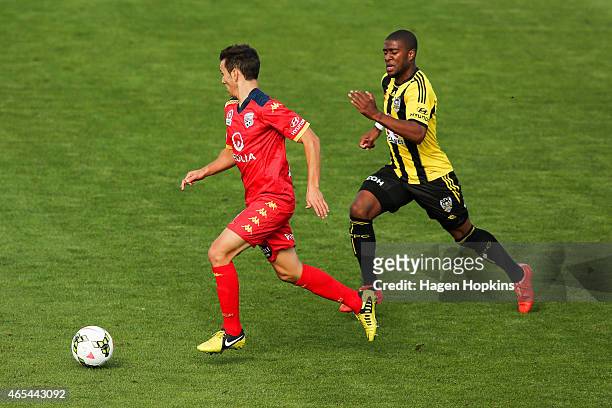 Isaias of Adelaide United runs the ball under pressure from Roly Bonevacia of the Phoenix during the round 20 A-League match between the Wellington...