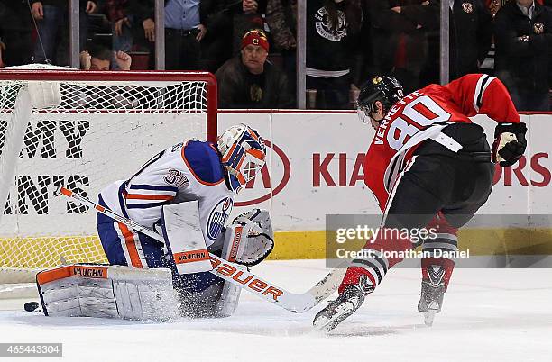 Antoine Vermette of the Chicago Blackhawks scores the game-winning goal in the shootout against Ben Scrivens of the Edmonton Oilers at the United...