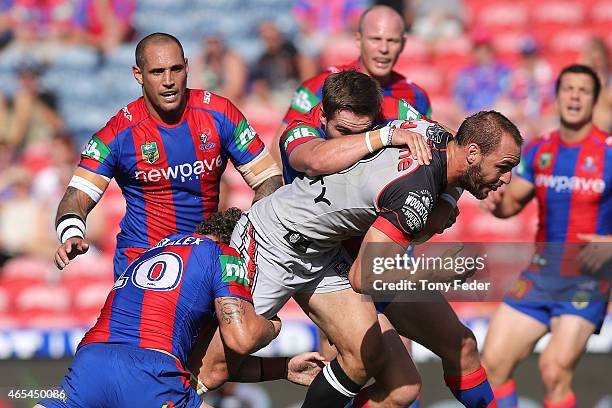 Simon Mannering of the Warriors is tackled by the Knights defence during the round one NRL match between the Newcastle Knights and the New Zealand...