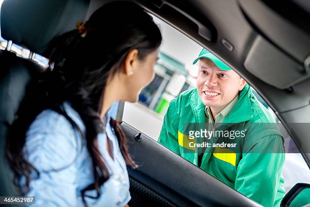 homem ajudando a mulher em um posto de gasolina - gas station imagens e fotografias de stock