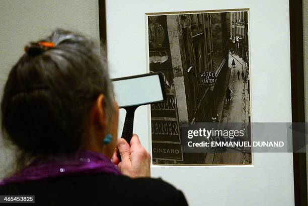 Visitor looks at pictures during a press preview for two exhibitions, "Charles Marville: A Photographer of Paris" and it's related show "Paris as...