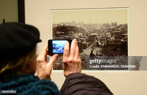 Visitor looks at a picture during a press preview for two exhibitions, "Charles Marville: A Photographer of Paris" and it's related show "Paris as...