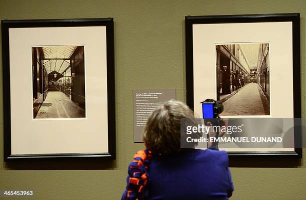 Visitor looks at pictures during a press preview for two exhibitions, "Charles Marville: A Photographer of Paris" and it's related show "Paris as...