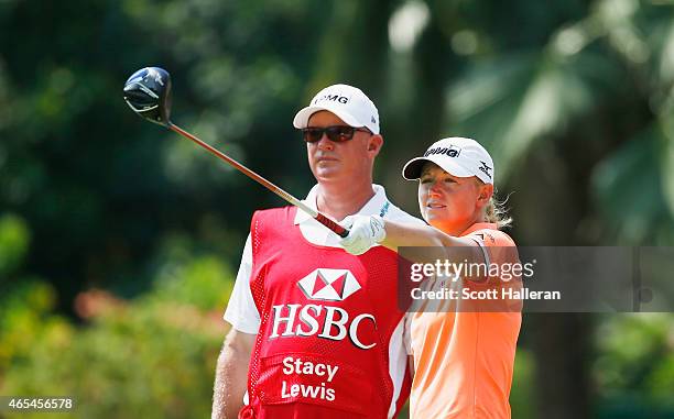 Stacy Lewis of the United States lines up her tee shot on the fifth hole with her caddie Travis Wilson during the third round of the HSBC Women's...