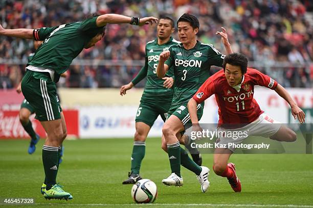 Kensuke Nagai of Nagoya Grampus and Hayuma Tanaka of Matsumoto Yamaga compete the ball during the J. League match between Nagoya Grampus and...