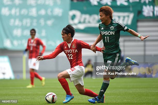 Tomoya Koyamatsu of Nagoya Grampus dribbles the ball under the pressure from Kohei Kiyama of Matsumoto Yamaga during the J. League match between...