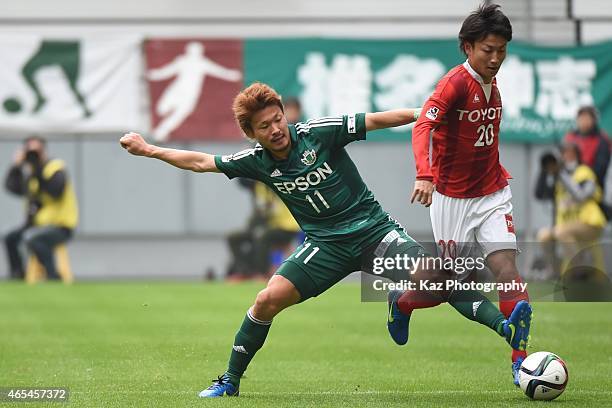 Asahi Yada of Nagoya Grampus passes Kohei Kiyama of Matsumoto Yamaga during the J. League match between Nagoya Grampus and Matsumoto Yamaga at Toyota...