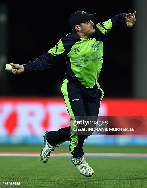 Ireland cricketer William Porterfield celebrates taking a catch to dismiss unseen Zimbabwe batsman Tawanda Mupariwa at the Bellerive Oval ground...